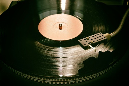 Turntable playing vinyl close up with needle on the record with grey backgroundの写真素材