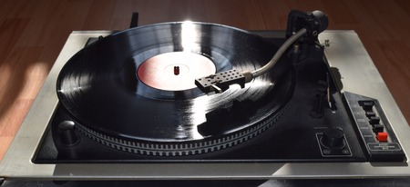 Turntable playing vinyl close up with needle on the record with grey backgroundの写真素材