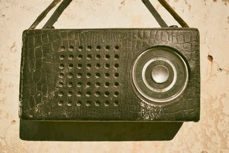 Old radio in a leather case with small strapの写真素材