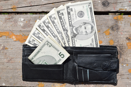 purse with money on a wooden table