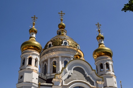 orthodox crosses on gold domes blue sky with clouds