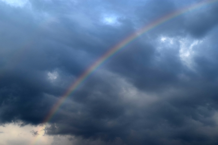 Beautiful rainbow with clouds and rain . It's springの写真素材