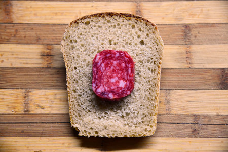 Sourdough bread with cut slices on a wooden table on black background with free space for textの写真素材
