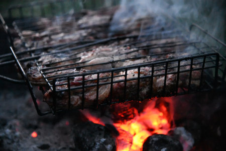 Beef steak on the grill with smoke and flamesの写真素材
