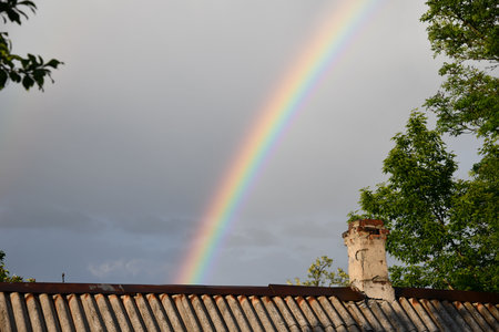 The end of a rainbow with a field in the foregroundの写真素材