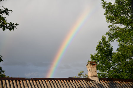 The end of a rainbow with a field in the foregroundの写真素材