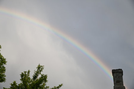 The end of a rainbow with a field in the foregroundの写真素材
