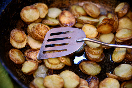 Baked in the oven potatoes with spices in a pan on a wooden table. The concept of delicious and healthy home-cooked food. Rustic style. Organic vegetablesの写真素材