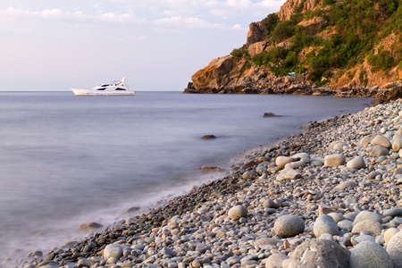 The boat near the rocky coast of the seaの写真素材