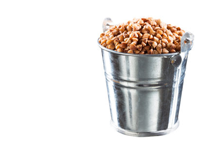 Buckwheat groats in a bucket on a white backgroundの写真素材