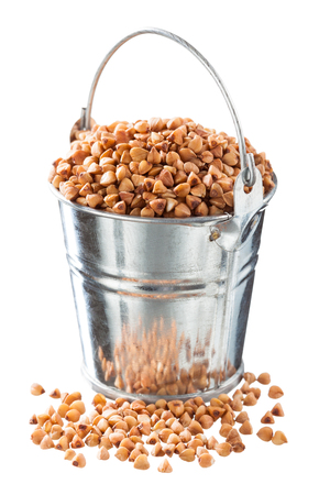 Buckwheat groats in a bucket on a white backgroundの写真素材