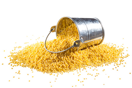 Millet in a bucket on a white backgroundの写真素材