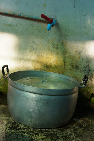 Water running from tap to potの写真素材