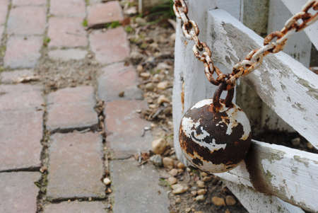 Rusty ballweight keeping fence door open.の写真素材