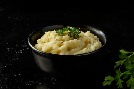 Delicious creamy mashed potatoes with butter, fresh herbs and freshly-cracked black pepperの素材