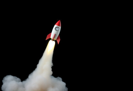 A red and white toy rocket launching into the air with a white smoke trail against a black background.の素材