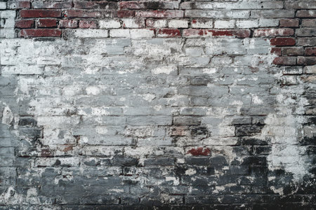 A close-up of an old brick wall with peeling white paint, revealing the red brick underneath, creating a textured and aged look.の素材