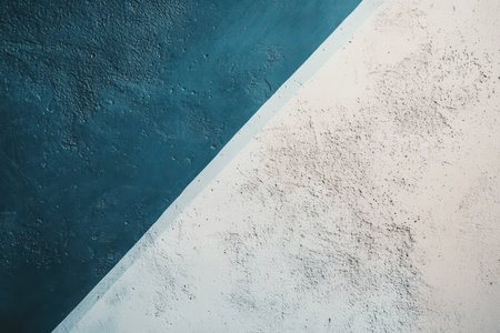 A close-up abstract image of a diagonal split in a textured surface, with one side painted blue and the other white.の素材