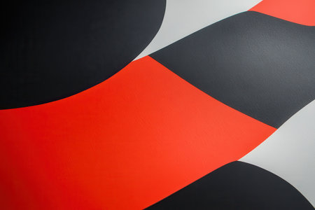 The image showcases a close-up view of an abstract geometric pattern composed of black, red, and white curved shapes, creating a visually engaging and modern design.の素材
