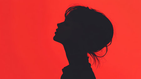 A minimalist image of a woman&#39;s silhouette against a red background.の素材