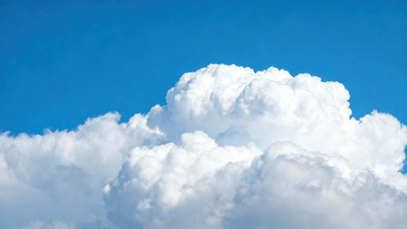 View of large, dense, cumulus clouds against a bright, vivid blue sky, suggesting a sunny day.