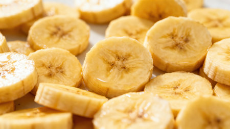 Collection of sliced bananas arranged in a close-packed manner, exhibiting their golden color and the interior details of the fruit.の写真素材