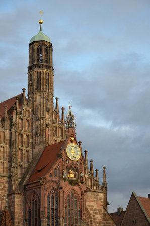 Fragment of the facade of the Frauenkirche ("Church of Our Lady"). In the foreground part of the "Beautiful Fountain" / blurred focus. Nuremberg, Germany.の写真素材