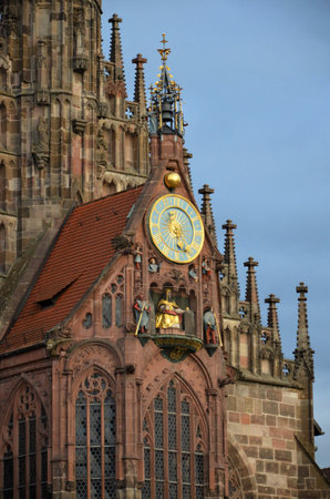 Fragment of the facade of the Frauenkirche ("Church of Our Lady"). In the foreground part of the "Beautiful Fountain" / blurred focus. Nuremberg, Germany.の写真素材
