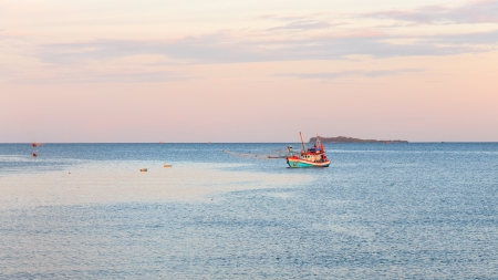sunset with boat fishing on seaの写真素材