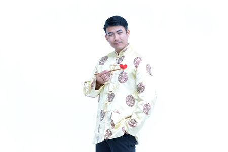 China young man,Asian man wear  dress chinese style cheongsam and holding chopsticks  with heart concept loveの写真素材
