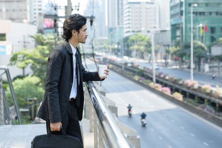 smart businessman hand holding a cup of coffee and bag office relax before working dayの写真素材