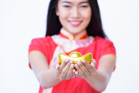 chinese woman hand holding gold for gift on Chinese New Year ,Asian women wear red dress chinese style cheongsamの写真素材