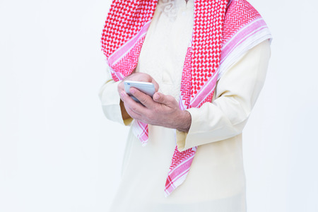 Arab man sharing social media on the smartphone isolated on a white backgroundの写真素材