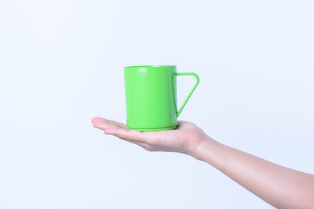 hand holding Plastic glass color isolated on white backgroundの写真素材