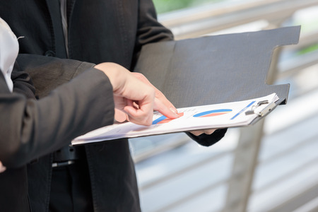 businessman and businesswoman talking about graph on work dayの写真素材