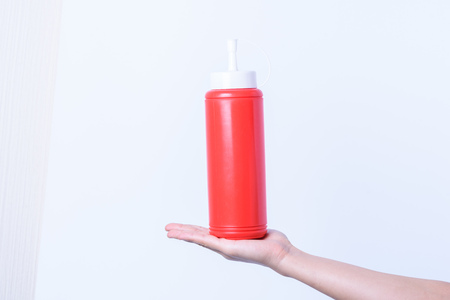 hand holding plastic sauce bottle for junk foodの写真素材