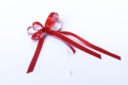 Red ribbon bow on white backgroundの写真素材