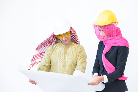 beautiful modern muslim architecture worker woman and arab young man work blueprint today on white backgroundの写真素材