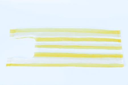 Yellow  striped  plastic bag on white backgroundの写真素材
