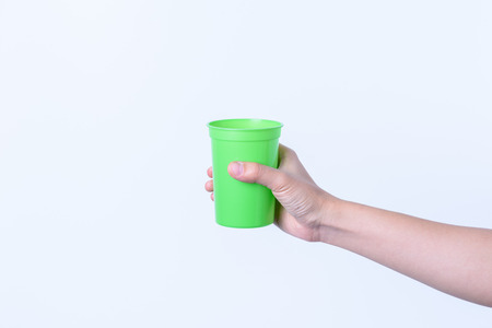 hand holding Plastic glass color isolated on white backgroundの写真素材