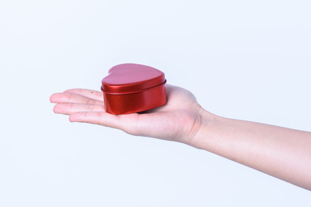hand on red heart box on white backgroundの写真素材