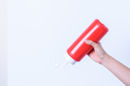 hand holding plastic sauce bottle for junk foodの写真素材