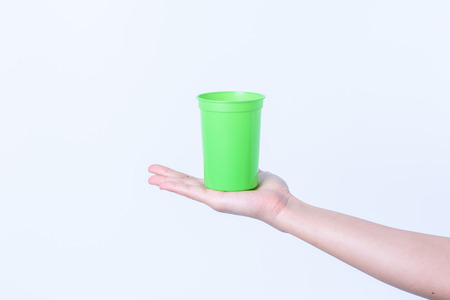hand holding Plastic glass color isolated on white backgroundの写真素材