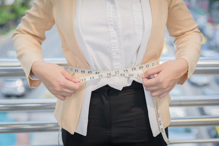 business woman standing and hand pull tourniquet concept dietの写真素材