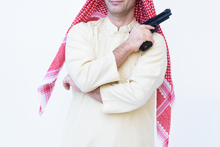 Arab man standing with hand holding black gunの写真素材