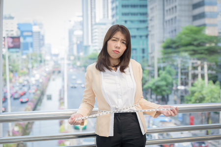 business woman standing and hand pull tourniquet concept dietの写真素材