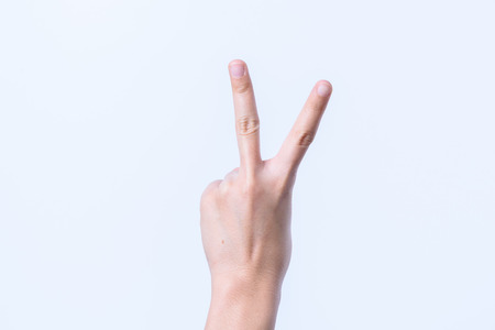 Hand women asian two finger symbol isolated on white backgroundの写真素材