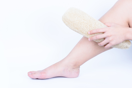 hand holding with leg loofah zucchini natural sponge for body clean dirt and dead skin isolated on whiteの写真素材