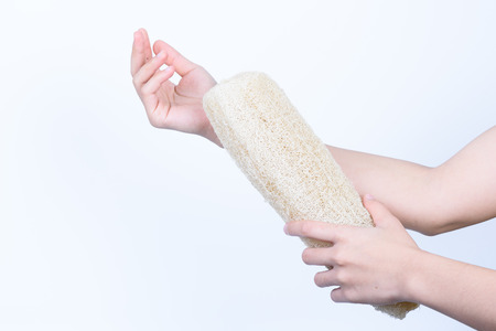 two hands holding loofah zucchini natural sponge for body clean dirt and dead skin isolated on whiteの写真素材