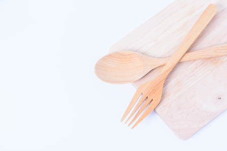 fork and wooden spoon on wood with white backgroundの写真素材